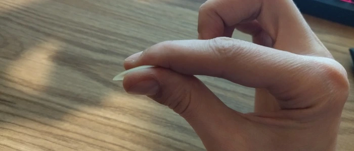 holding a guitar pick for strumming